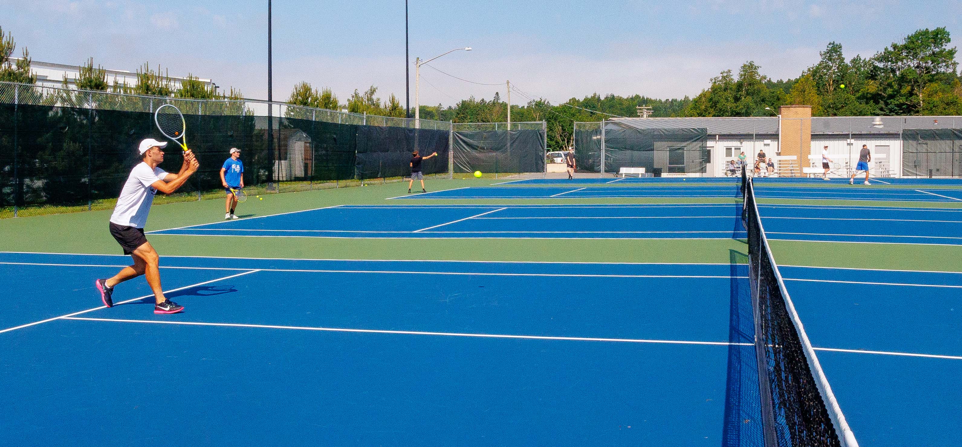 Man returning the shot on tennis court.