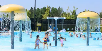 Mushroom water spray feature with kids playing.