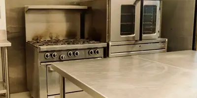 Kitchen with commercial fridge, stove.